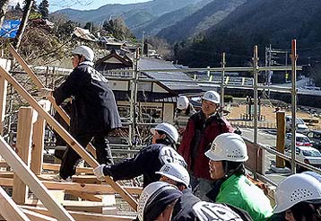 柱・梁と順番に組みあがって最後に屋根のタルキを架け渡すこども達